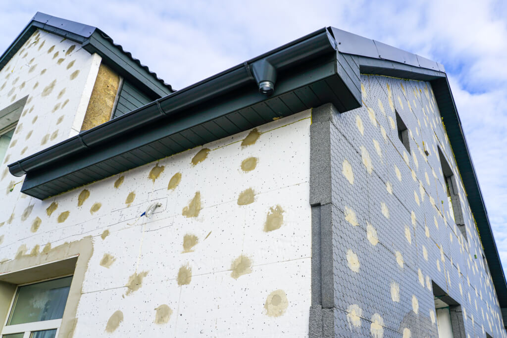 Photo extérieur d'une rénovation globale de maison, avec des plaques isolantes ajoutées sur la facade